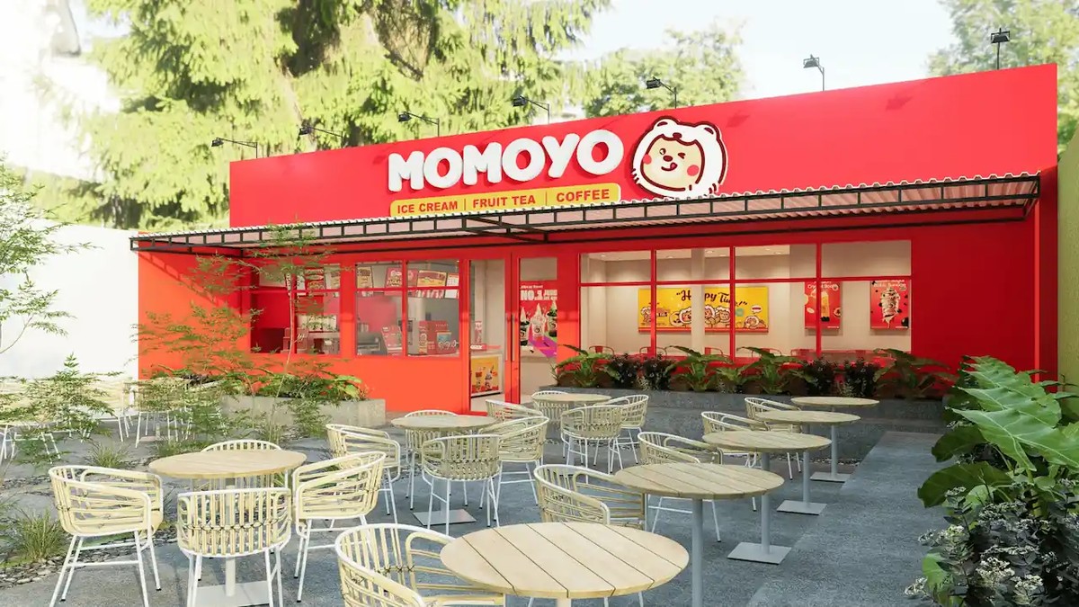 Gerai resmi Momoyo Standard Store dengan fasad merah, logo terbaru, dan area tempat duduk outdoor